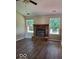 Living room features a red brick fireplace, hardwood floors, and natural light from two windows at 5822 Blackley Ln, Indianapolis, IN 46254