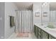 Light-filled bathroom with double sink vanity, granite counters, tile flooring and shower with decorative curtain at 5839 Beacon Cove Way, Indianapolis, IN 46237