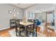 Cozy dining area with hardwood floors, a modern table setting, and an open view into the living room at 5839 Beacon Cove Way, Indianapolis, IN 46237