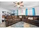 Inviting living room featuring two brown sofas, bright windows and ceiling fan with decorative rug at 637 Woods Crossing Dr, Indianapolis, IN 46239