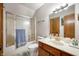 Bright bathroom featuring a shower-tub combo, cherry vanity, and neutral finishes at 6520 Forrest Commons Blvd, Indianapolis, IN 46227