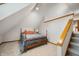 Attic bedroom featuring carpeted floors, a wooden bed frame, and a staircase leading down at 6520 Forrest Commons Blvd, Indianapolis, IN 46227