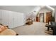 A bonus room has carpeted floors, white walls, a sewing table, a bed, and lots of natural light at 6520 Forrest Commons Blvd, Indianapolis, IN 46227
