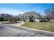 Wide front view of home with circular driveway, arched windows, mature trees, and lush lawn at 6520 Forrest Commons Blvd, Indianapolis, IN 46227