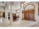 Bright foyer with high ceilings, arched doorway, tile floors, decorative rug, and statement lighting at 6520 Forrest Commons Blvd, Indianapolis, IN 46227