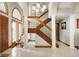 Bright foyer with tile floors, arched window, decorative wood stairs with metal handrail, and statement lighting at 6520 Forrest Commons Blvd, Indianapolis, IN 46227