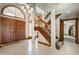 Bright foyer with tile floors, wood stairs, arched window, statement lighting, and front door at 6520 Forrest Commons Blvd, Indianapolis, IN 46227
