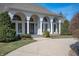 Close up front exterior of home featuring a curved drive, arched windows, and lush bushes at 6520 Forrest Commons Blvd, Indianapolis, IN 46227