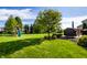 Large, well-manicured backyard with playset, lush lawn and an outdoor kitchen area at 664 Hythe Way, Westfield, IN 46074