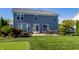 Backyard view with outdoor patio and grilling area, putting green, and lush lawn at 664 Hythe Way, Westfield, IN 46074