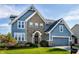 Charming two-story home with a brick facade, blue siding, and well-manicured lawn at 664 Hythe Way, Westfield, IN 46074