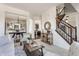 Open-concept living room featuring a staircase, neutral decor, and hardwood floors at 664 Hythe Way, Westfield, IN 46074