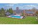 Aerial view of backyard featuring a pool, patio, and well-manicured lawn at 6778 Old Hunt Club Rd, Zionsville, IN 46077