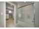 Bright bathroom featuring a tub with glass doors, shower and open view to the walk-in closet at 6778 Old Hunt Club Rd, Zionsville, IN 46077