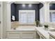 Elegant bathroom showcases a soaking tub by a window with shutters, with dark blue accent wall and vanity space at 6778 Old Hunt Club Rd, Zionsville, IN 46077