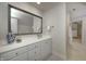 Bathroom featuring white vanity with silver hardware, large mirror, and a doorway leading to the walk in closet at 6778 Old Hunt Club Rd, Zionsville, IN 46077