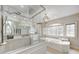 Bright bathroom featuring a soaking tub under a large window and a glass enclosed shower at 6778 Old Hunt Club Rd, Zionsville, IN 46077