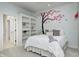 Bright bedroom featuring a whimsical tree wall decal, built in shelves and an en-suite bathroom at 6778 Old Hunt Club Rd, Zionsville, IN 46077
