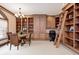 Wood-paneled home office with custom built-ins, chandelier lighting and a charming library ladder at 6778 Old Hunt Club Rd, Zionsville, IN 46077