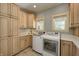 Charming laundry room with ample storage cabinets, dual windows, and updated washer and dryer set at 6778 Old Hunt Club Rd, Zionsville, IN 46077