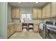 Bright laundry room with cabinets, countertops, modern appliances, and travertine flooring at 6778 Old Hunt Club Rd, Zionsville, IN 46077