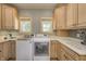 Bright laundry room features custom cabinets, solid surface countertop, undermount sink, and modern washer and dryer at 6778 Old Hunt Club Rd, Zionsville, IN 46077