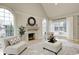 Bright living room with a fireplace, arched windows, and comfortable seating at 6778 Old Hunt Club Rd, Zionsville, IN 46077