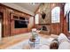 Cozy living room with stone fireplace, wood paneling, and comfortable seating area at 6778 Old Hunt Club Rd, Zionsville, IN 46077