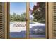 Pool view through shuttered french doors revealing an inviting outdoor pool area with a table and mature trees at 6778 Old Hunt Club Rd, Zionsville, IN 46077