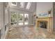 Bright sunroom with a fireplace and tile floors offers scenic views and backyard access at 6778 Old Hunt Club Rd, Zionsville, IN 46077