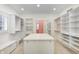 Spacious walk-in closet with custom shelving and storage and a large center island at 6778 Old Hunt Club Rd, Zionsville, IN 46077