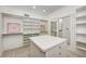 Bright walk-in closet with custom shelving and storage and a large center island at 6778 Old Hunt Club Rd, Zionsville, IN 46077