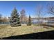 Lush backyard view featuring a pond and mature trees, creating a serene and private outdoor space at 7156 Long Shore Cir, Indianapolis, IN 46217