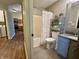 Updated bathroom with decorative shower curtain, modern vanity, and stylish shelving; kitchen in background at 7156 Long Shore Cir, Indianapolis, IN 46217