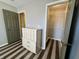 Bedroom with drawers and closet, showcasing striped flooring and neutral walls; door leading to storage at 7156 Long Shore Cir, Indianapolis, IN 46217