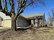 Charming single-story home featuring a brick facade, attached garage, and mature tree in a landscaped yard at 7156 Long Shore Cir, Indianapolis, IN 46217