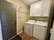 View of the laundry room complete with washer and dryer, white cabinets, and hardwood flooring at 7156 Long Shore Cir, Indianapolis, IN 46217