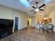 Spacious living room with skylights, ceiling fan, wood flooring, and TV at 7156 Long Shore Cir, Indianapolis, IN 46217