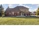 Home's back exterior with a brick and siding facade, plus a well-maintained lawn and a deck for outdoor entertaining at 7619 Bluebird Ct, Brownsburg, IN 46112