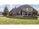 Home's back exterior featuring a mix of brick and siding, a well-kept lawn, and a deck ideal for relaxation and gatherings at 7619 Bluebird Ct, Brownsburg, IN 46112