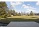 View of the expansive backyard with a wooden deck, lush lawn, mature trees, and blue sky, perfect for outdoor enjoyment at 7619 Bluebird Ct, Brownsburg, IN 46112