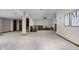 Expansive carpeted basement with a large sectional sofa, lighting, and a staircase at 7619 Bluebird Ct, Brownsburg, IN 46112