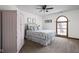 Bedroom featuring a metal frame bed, floral bedding, ceiling fan, and arched window at 7619 Bluebird Ct, Brownsburg, IN 46112