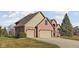 The right side of this red brick home showcases a two-car attached garage and pristine lawn at 7619 Bluebird Ct, Brownsburg, IN 46112