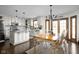 Open kitchen with white cabinets, stainless appliances, granite countertops, and a dining area with decorative light fixture at 7619 Bluebird Ct, Brownsburg, IN 46112