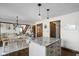 Open-concept kitchen featuring an island with granite countertop and a view into the dining and living areas at 7619 Bluebird Ct, Brownsburg, IN 46112