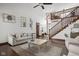Open concept living room with hardwood floors and view of staircase with wood banister at 7619 Bluebird Ct, Brownsburg, IN 46112