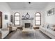 The light filled living room features a fireplace, mantel, and large arched windows at 7619 Bluebird Ct, Brownsburg, IN 46112
