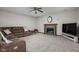 Cozy living room featuring a fireplace, ceiling fan, comfortable couch and large TV at 7619 Bluebird Ct, Brownsburg, IN 46112