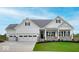 Charming exterior of a two-story home with a manicured lawn, covered porch and multi-car garage at 7707 Walker Dr, Avon, IN 46123